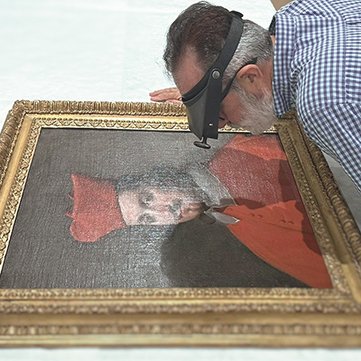 Conservator examining a painting
