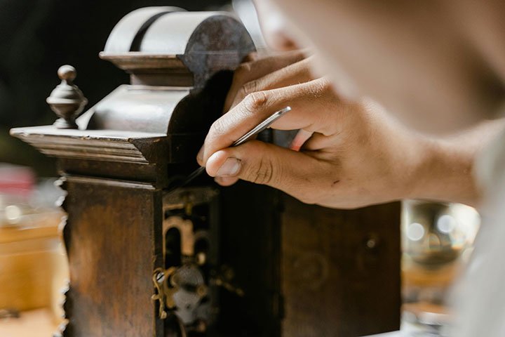 A close up of an objects conservator working on a propject